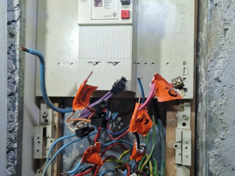 Ancien tableau électrique avec circuits repérés par étiquettes avant remplacement